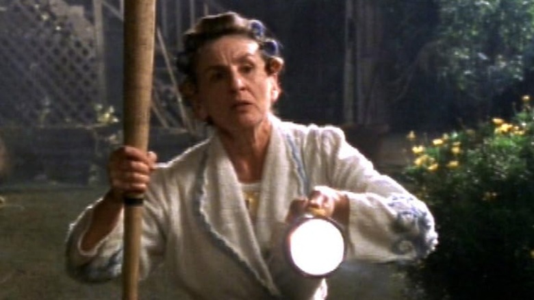 A woman holding a bat and flashlight on Beyond Belief: Fact or Fiction (1997 - 2026)