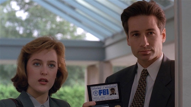Fox Mulder and Dana Scully holding up ID badge to be let inside on The X-Files (1993 - 2018)