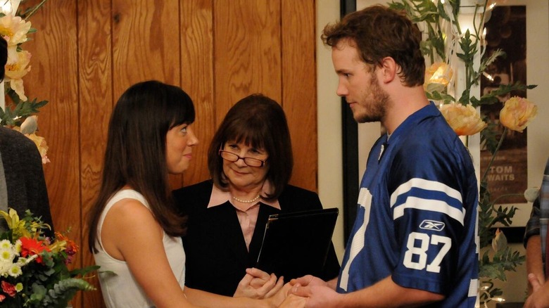 April and Andy holding hands at the altar