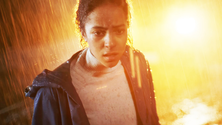 Lou Llobell's Maddie stands in a rainstorm in Passenger
