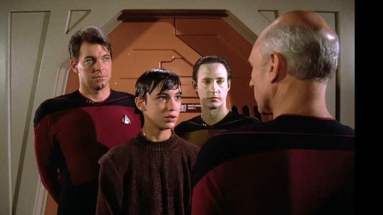 Riker, Wesley, and Data stand in front of Picard
