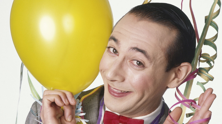 Pee-wee smiling with a balloon