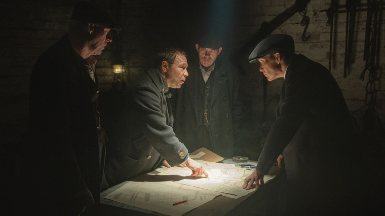 Johnny Dogs, Hayden Stagg, Charlie Strong, and Tommy Shelby talking around a table in 