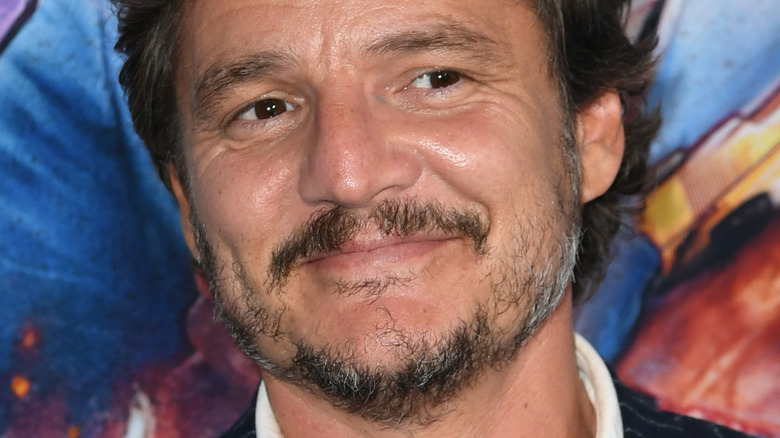 Pedro Pascal smiling and looking left