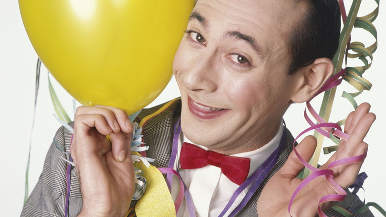 Pee-wee smiling with a balloon