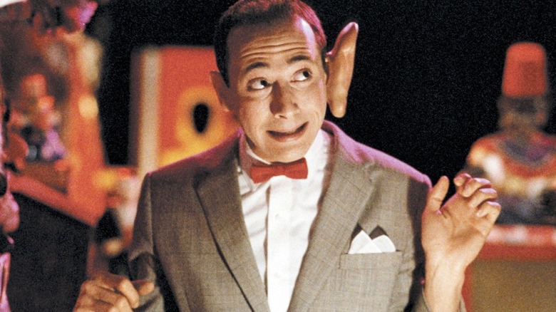 Pee-wee Herman stands with oversized novelty ear