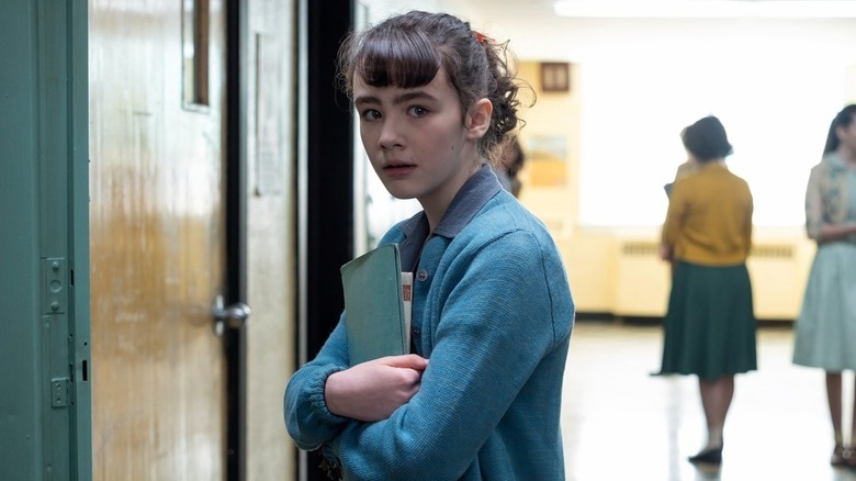 Clara Stack's Lilly Bainbridge holding her books in It: Welcome to Derry