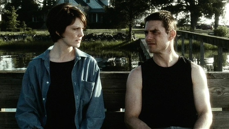 Lara and John sitting on a bench outside in Minority Report