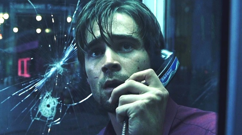 Stu Shepard on a phone in a booth with a bullet hole in the glass