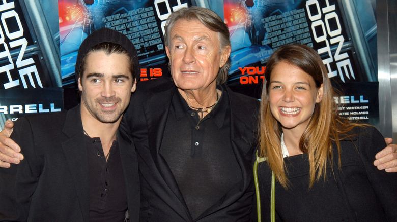 Colin Farrell, Joel Schumacher, and Katie Holmes posing for a photo in front of a Phone Booth display