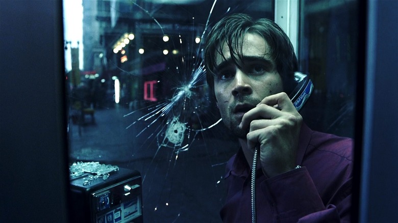 Stu Shepard on a phone in a booth with a bullet hole in the glass