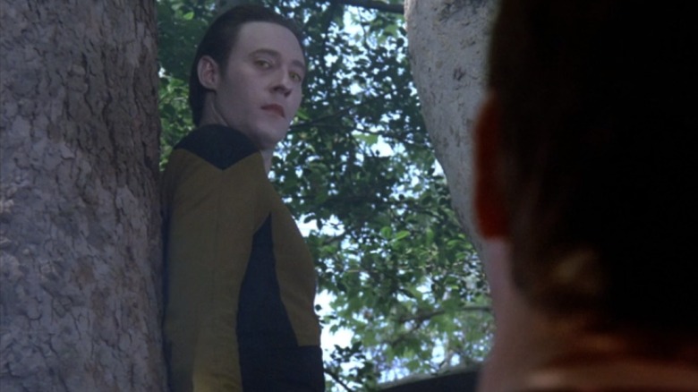 Data standing in a tree and looking at Will Riker