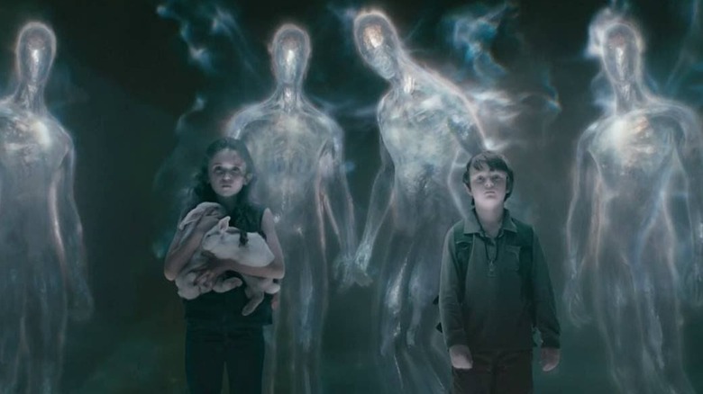 Lucinda and Caleb stand in a void surrounded by glowing aliens in Knowing (2009)