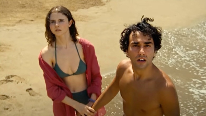 Trent and Maddox on the beach, looking into the sky in Old (2021)
