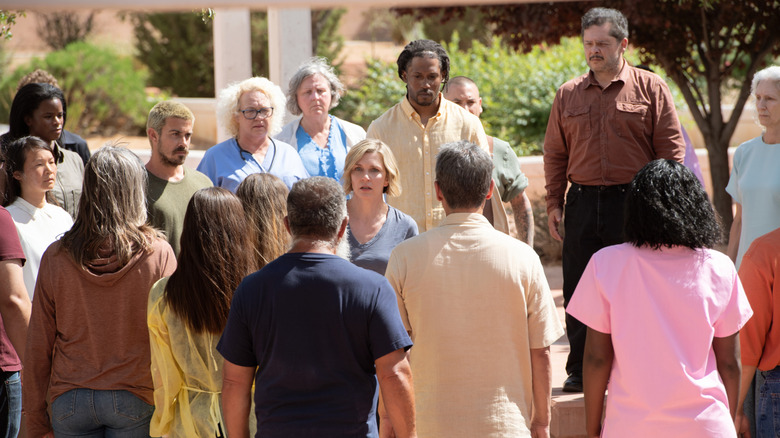 Pluribus crowd around Carol outside hospital