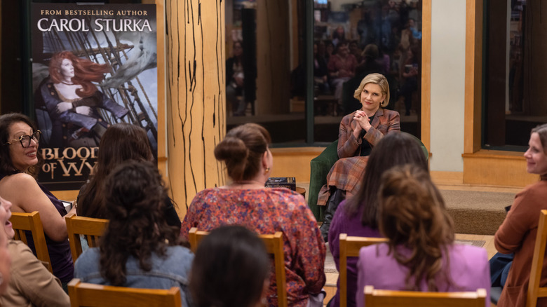 Carol sitting on stage at a book signing
