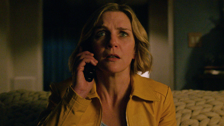 Carol Sturka talks on the phone in a bedroom in 