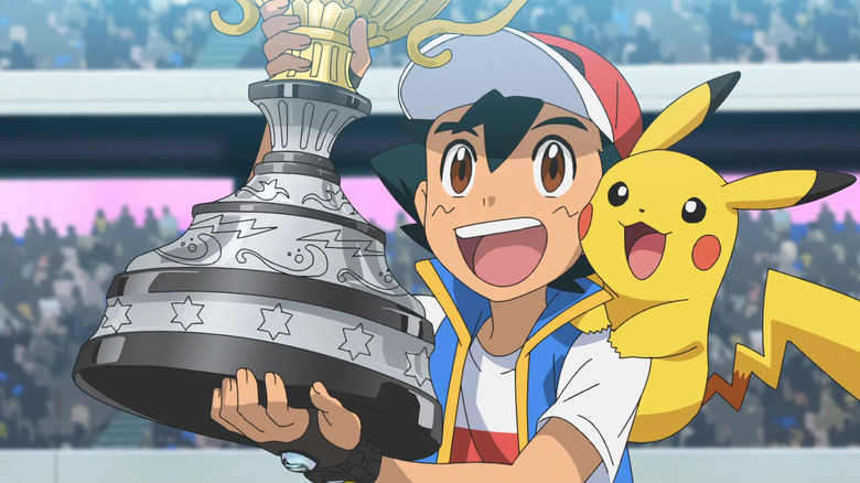 Ash holds his championship trophy, with Pikachu on his shoulder