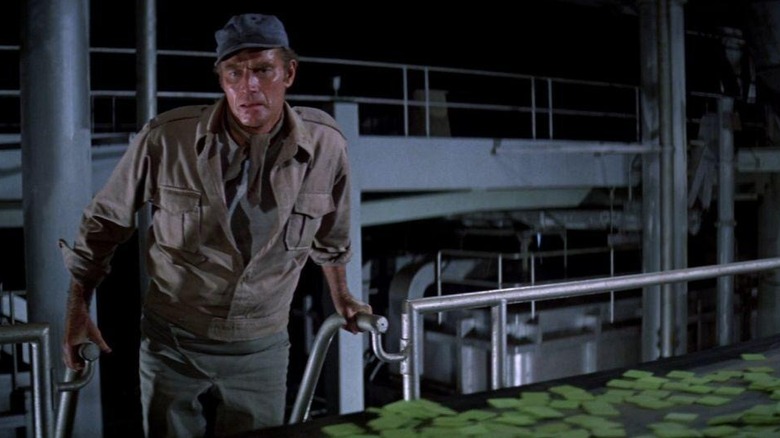 Charlton Heston watches conveyor belt