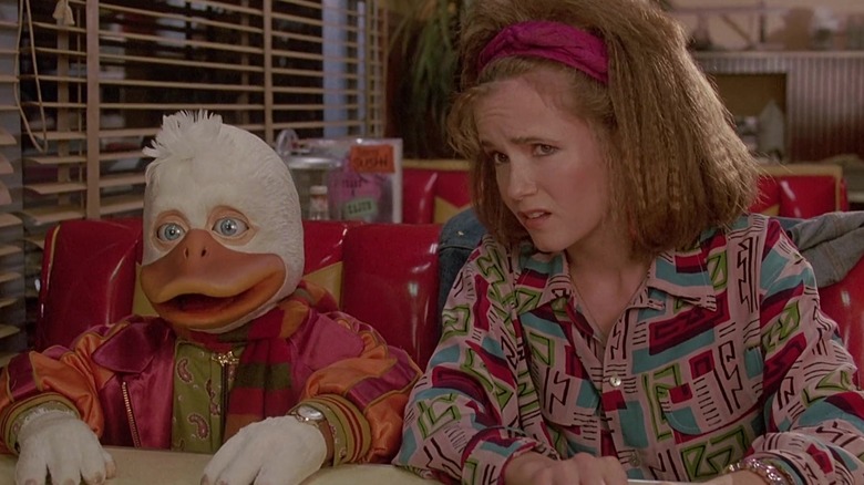 Beverly and Howard looking unsure in a restaurant booth