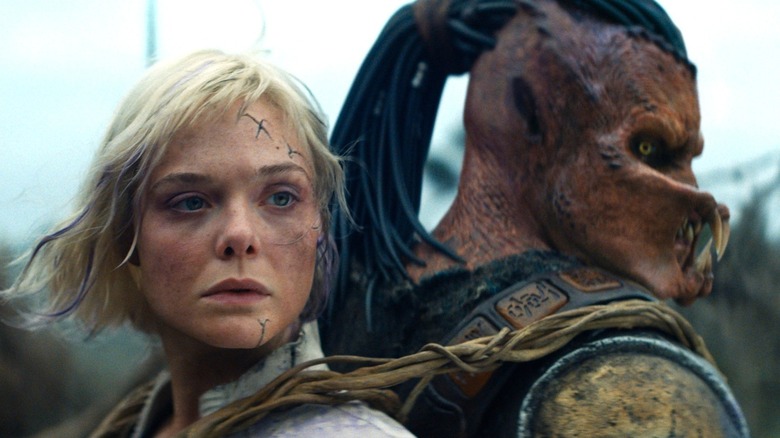 Dek carrying Thia on his back in "Predator: Badlands" (2025)