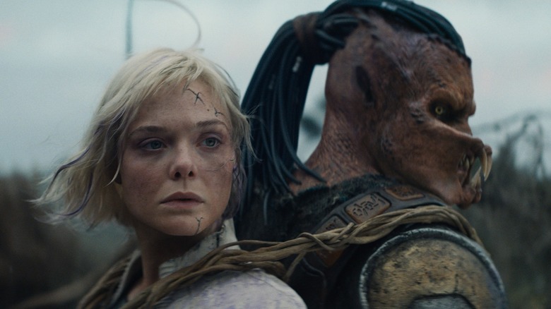 Thia strapped to Dek's back in Predator: Badlands