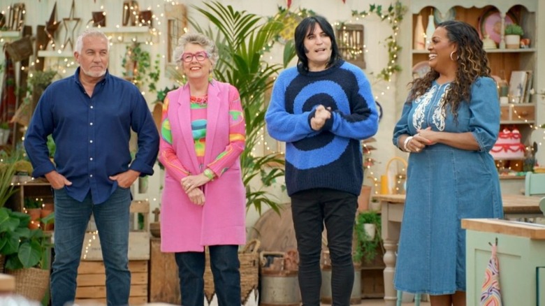 Paul Hollywood stands next to Prue Leith, Noel Fielding, and Alison Hammond in the tent in The Great British Bake Off