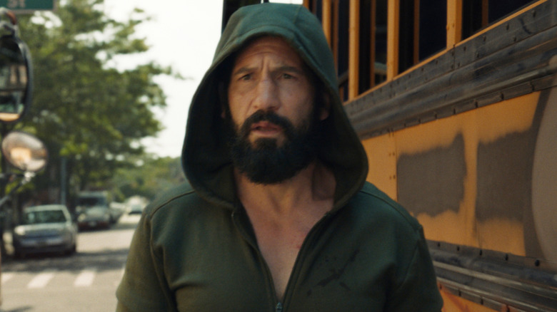 A hooded Frank Castle stands between school buses in "The Punisher: One Last Kill" (2026)