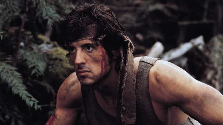 Rambo crouching down in the forest in First Blood (1982)