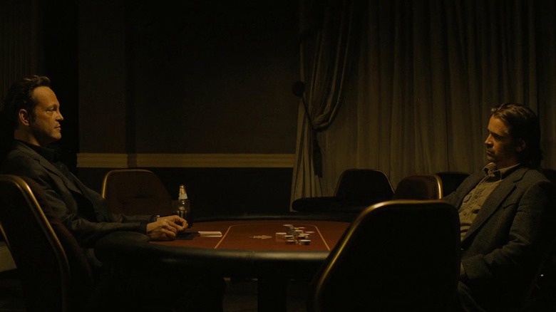 Velcoro and Semyon sit across each other on a table and stare each other down