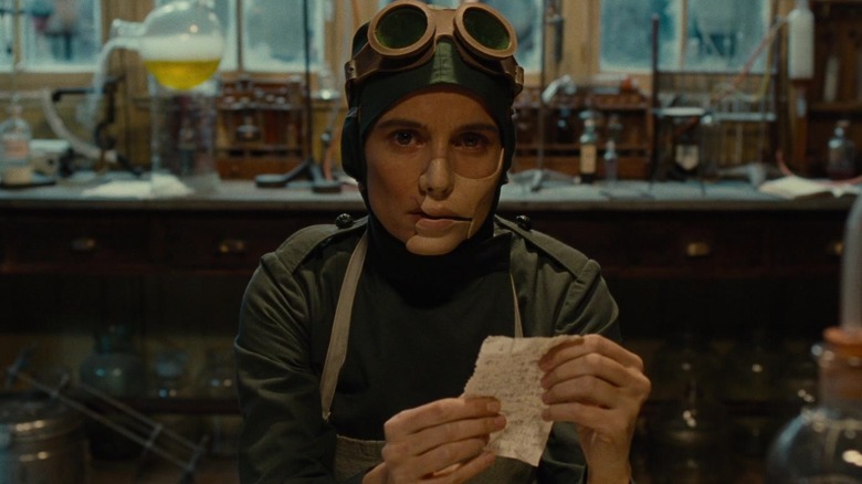 Doctor Poison holds a paper in her hands