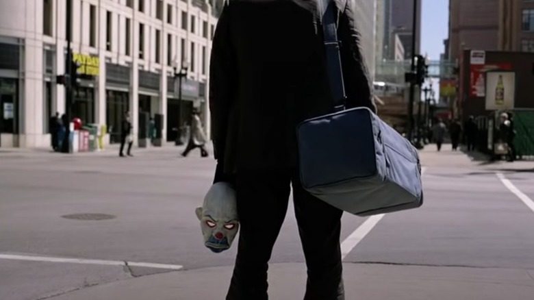 The Joker holding mask bag