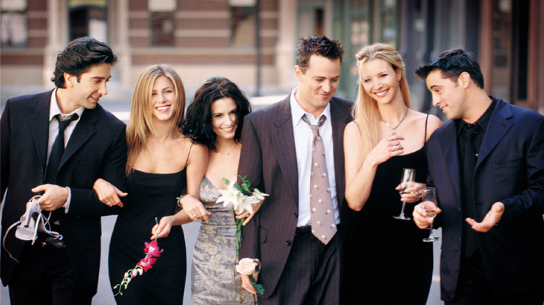 Friends cast walking and smiling