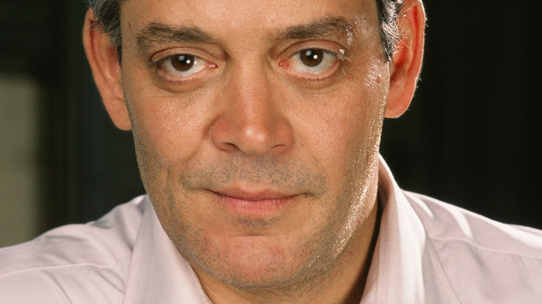 Raul Julia smirking