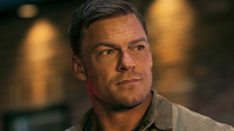 Alan Ritchson looking to the left on the set of Reacher