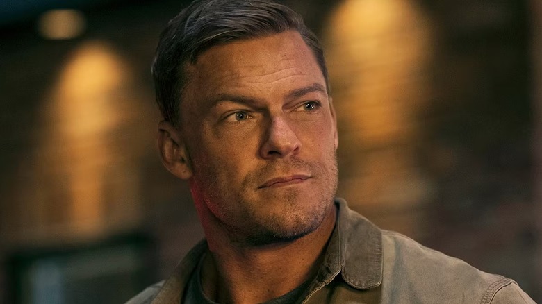 Alan Ritchson looking to the left on the set of Reacher
