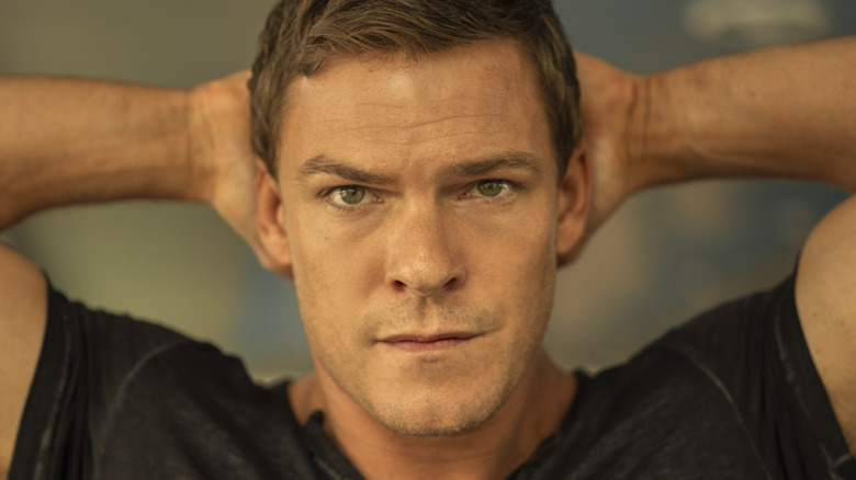 Jack Reacher hands on his head wearing black shirt