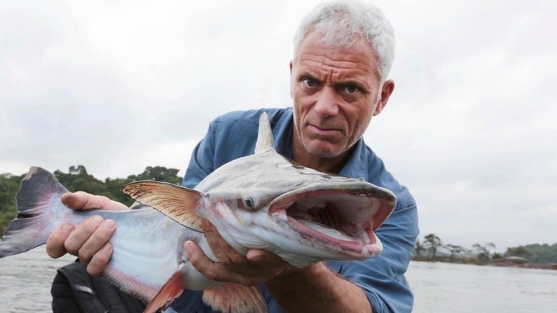   Jeremy Wade sostenint peixos