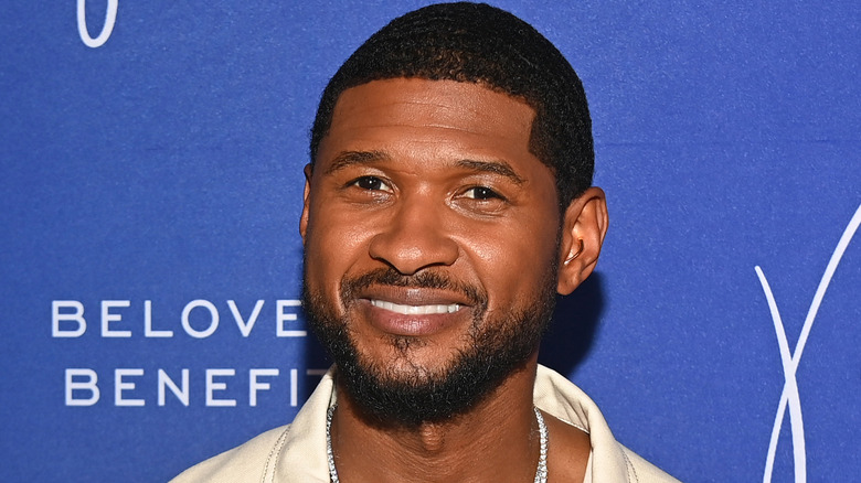 Usher smiling on a red carpet