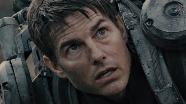Tom Cruise in mech suit lying on beach