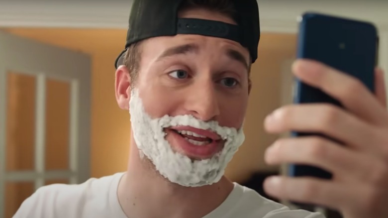 Man shaving and smirking