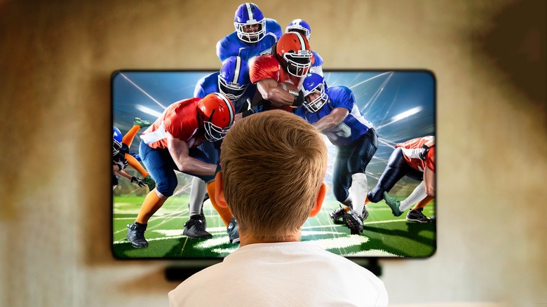 Football players jumping out of the TV 