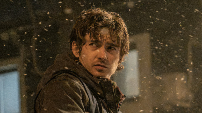 Bryan looking wary and standing outdoors while it's snowing in Resident Evil