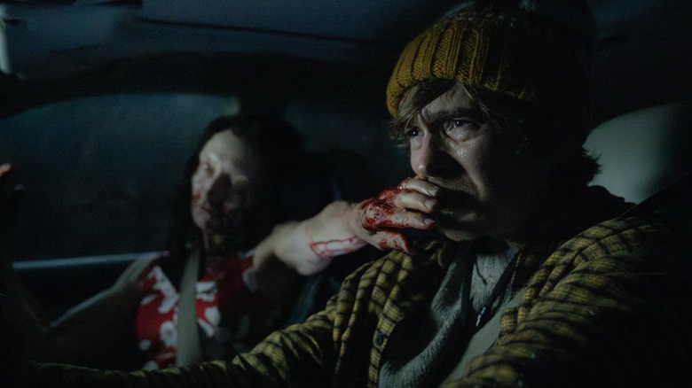 A woman passenger covers Bryan's mouth in "Resident Evil" (2026)