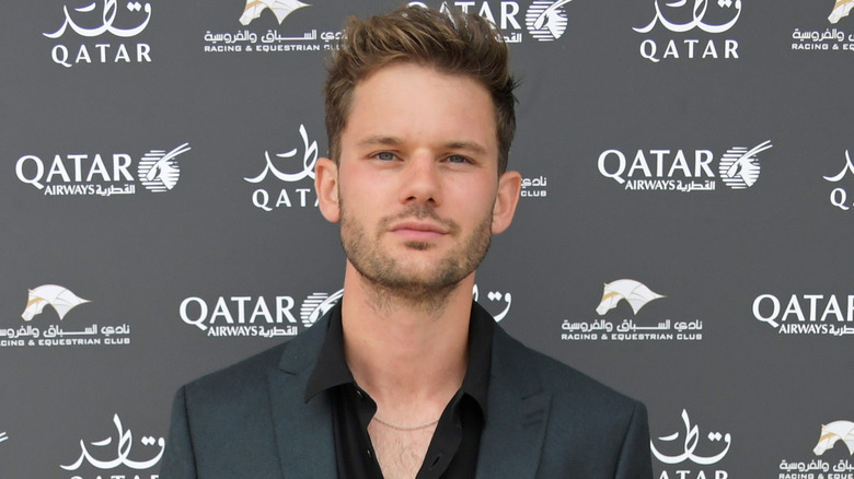 Jeremy Irvine wearing black suit