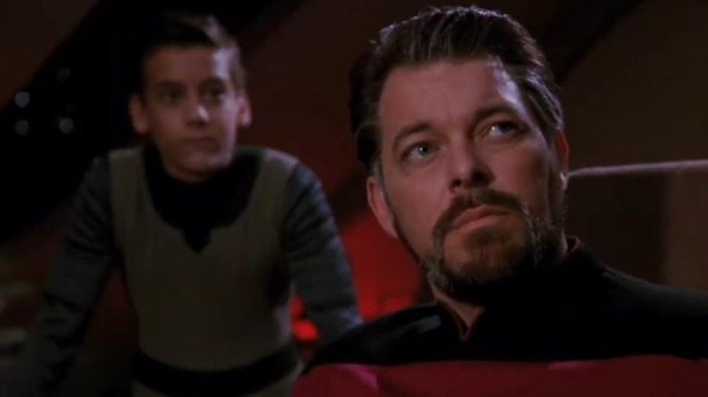 An aged-up Riker with a child standing behind him in Star Trek: The Next Generation (1987)