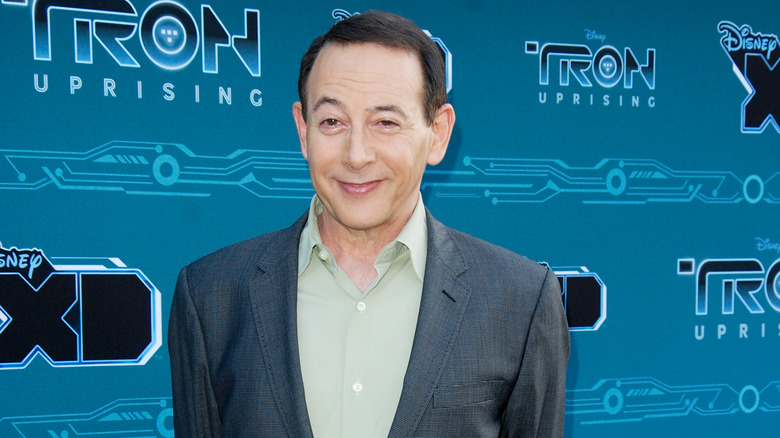 Paul Reubens wearing grey suit with pale green shirt