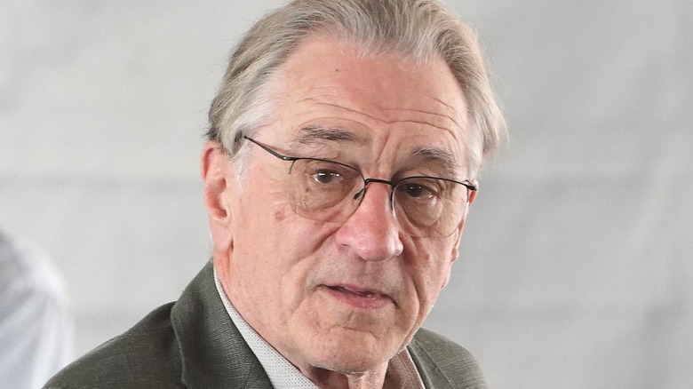 Robert De Niro wearing glasses glancing sideways