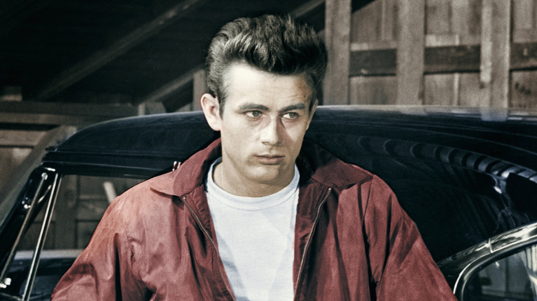 Jim Stark leans on a black car in "Rebel Without a Cause" (1955)