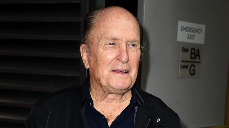 Robert Duvall standing near an emergency exit sign